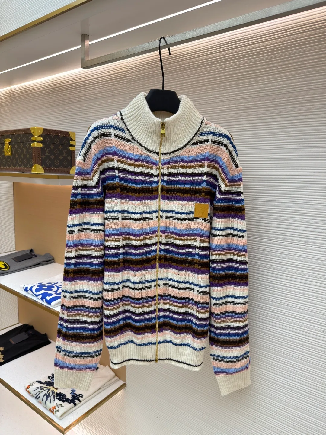 LOUIS VUITTON letter badge color block cable zipper knitted jacket ●Original version: purchased and developed by 21570 ●Item number: 1682322-C15 ●Fabric: wool blended fabric ●Technology: knitting ●Color: pattern ●Version: fitted version ●Weight: about 710 grams ●Size: S-M-L-XL ●Description: This Louis Vuitton color-blocked striped knitted cardigan is made of merino wool and cashmere blended yarn and is woven on a 12-needle coarse-gauge computerized flat knitting machine. The body is interlaced with cable knitting and plain knitting. The stripes are directly knitted with colored yarns instead of post-printing and dyeing. The ratio of colored yarns for each stripe is accurately calculated, making the color transition natural and not easy to fade. The placket is equipped with a customized brass zipper, and the zipper teeth are polished and gold-plated, which is both smooth and durable. The leather label on the left chest is fixed with first-layer calfskin through heat embossing process, and the edges are hand-polished without burrs. The neckline is designed with a high-elastic ribbed stand-up collar, which is not easily deformed after being shaped at high temperatures. The ribbed edges on the cuffs and hem are woven with double-strand yarn, which is more elastic. The shoulders are seamlessly woven with raglan sleeves to reduce the feeling of seams rubbing against the skin. The overall loose fit is combined with three-dimensional tailoring, which not only retains the soft texture of knitting, but also creates a crisp silhouette. Each piece is hand-ironed and quality-checked by brand craftsmen. The overall wiring is straight and delicate, the fabric is comfortable and soft, and the color is consistent without color difference. It can be matched with the same style to create a fashionable look and control various occasions. Customized accessories, complete with three standards, same style for men and women!